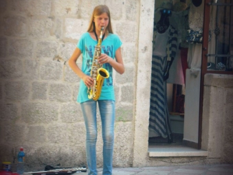 Montenegrin street musician pla the saxophone in Kotor