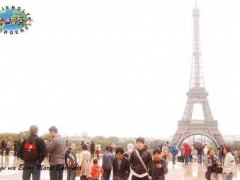 People walk around the Eiffel Tower