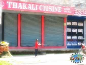 Thakali boy stands outside a restaurant in Pokhara, Nepal