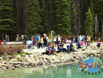 A crowd of people enjoy the serenity of Lake Louise in Alberta, Canada