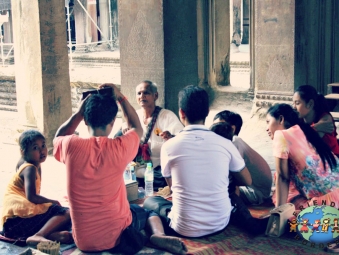 A khmer fortune teller guides a family at Angkor Wat in Siem Reap Province